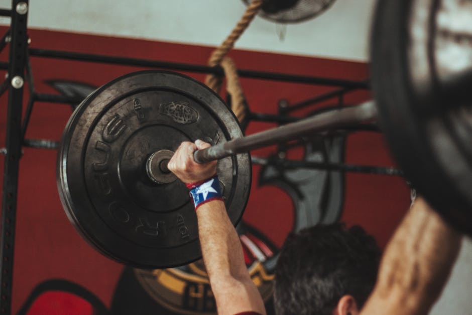 Athlete lifting heavy barbell during strength training session in gym