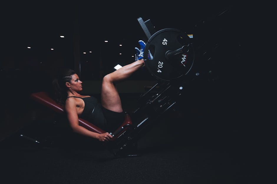 A woman engages in an intense leg press workout at the gym, showcasing strength and fitness