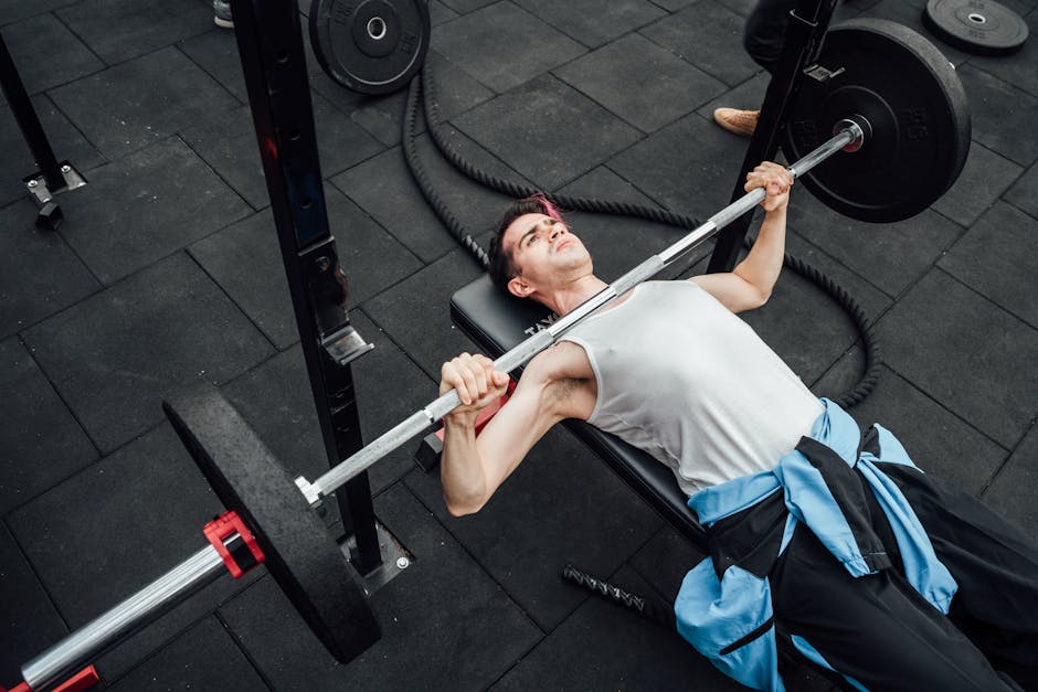 Adult male performing bench press in a Mexico City gym, showcasing strength training and fitness
